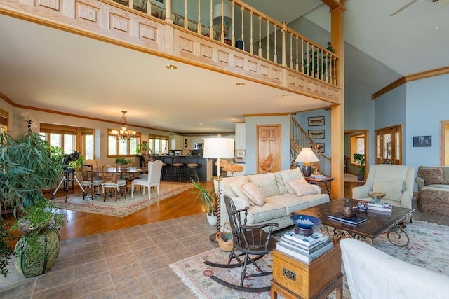 living room featuring an inviting chandelier, crown molding, light wood-type flooring, and a towering ceiling