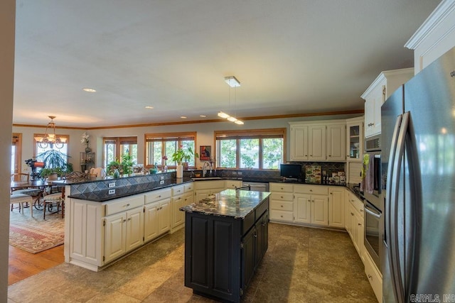 kitchen featuring sink, decorative light fixtures, a center island, appliances with stainless steel finishes, and kitchen peninsula