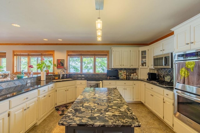 kitchen with white cabinetry, sink, a kitchen island, and appliances with stainless steel finishes