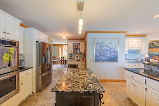 kitchen with white cabinetry, a center island, dark stone countertops, and appliances with stainless steel finishes