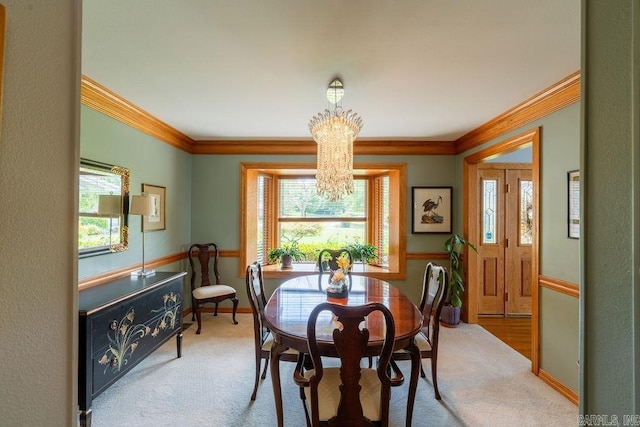 dining space with ornamental molding, a chandelier, and carpet