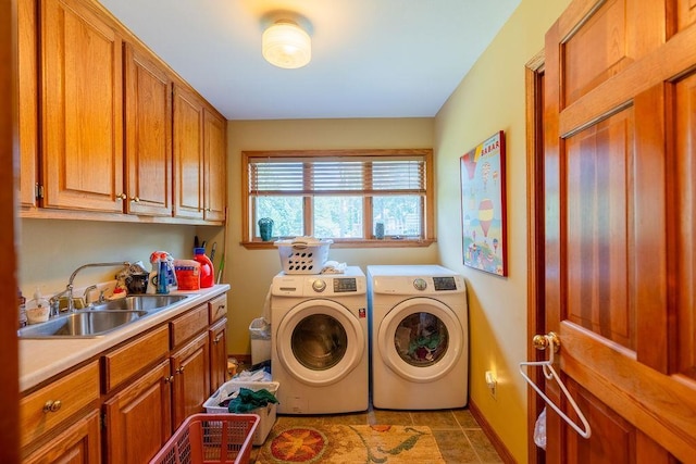 clothes washing area with cabinets, sink, light tile patterned floors, and independent washer and dryer