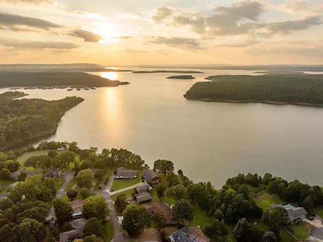 aerial view at dusk featuring a water view