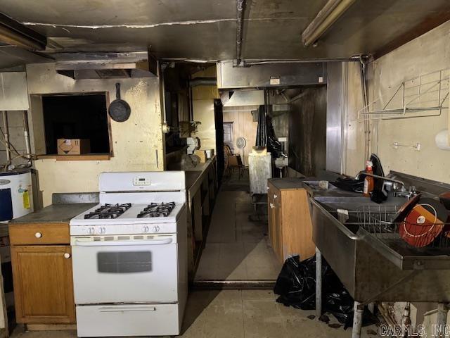 kitchen featuring fridge and white gas range oven
