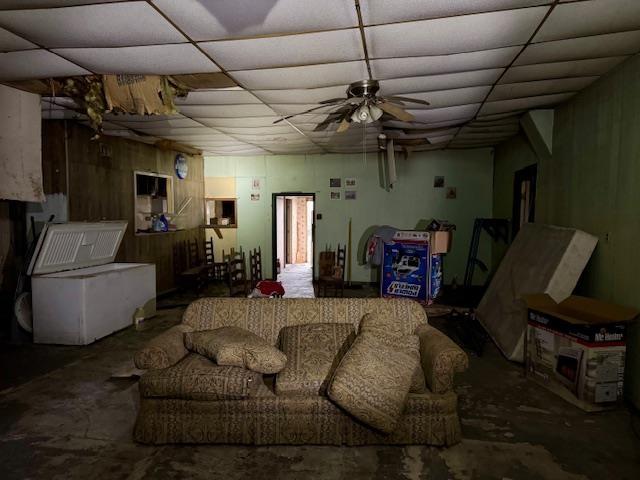 living room with a paneled ceiling and ceiling fan