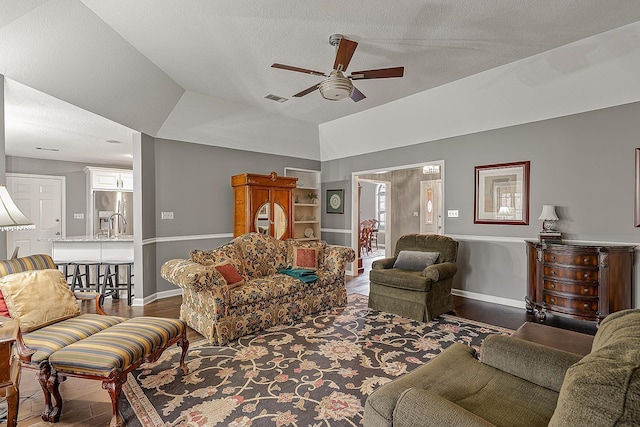 living room featuring ceiling fan, lofted ceiling, hardwood / wood-style floors, and a textured ceiling