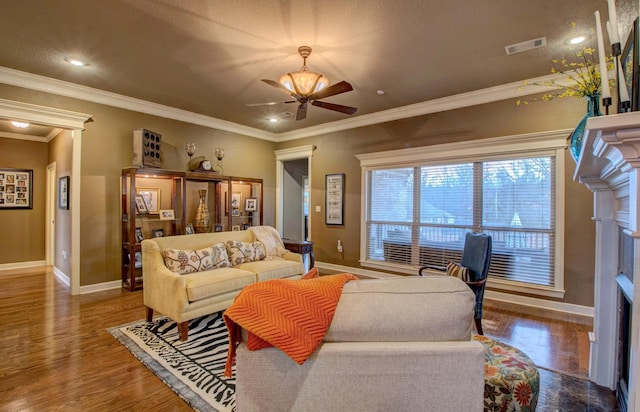 living room featuring dark wood-type flooring, ceiling fan, and crown molding