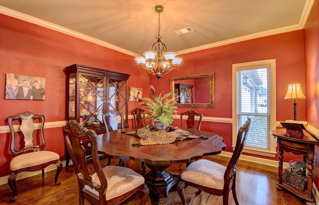 dining room with a notable chandelier, crown molding, and dark hardwood / wood-style floors