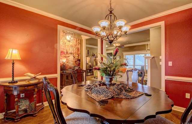 dining area with crown molding, wood-type flooring, and a chandelier