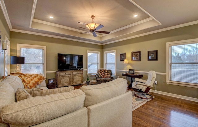 living room with crown molding, a raised ceiling, and hardwood / wood-style floors