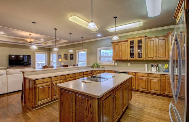 kitchen featuring a kitchen island, pendant lighting, stainless steel refrigerator, black electric stovetop, and light hardwood / wood-style flooring