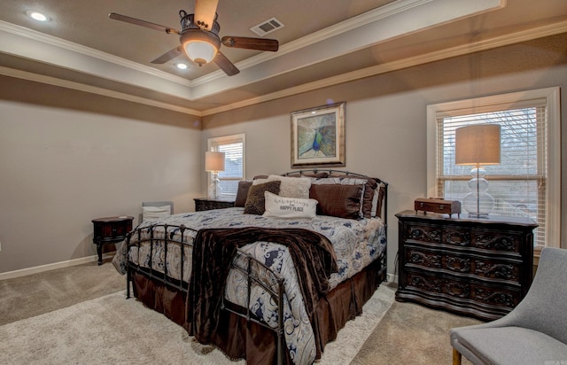 bedroom featuring crown molding, light colored carpet, a raised ceiling, and ceiling fan