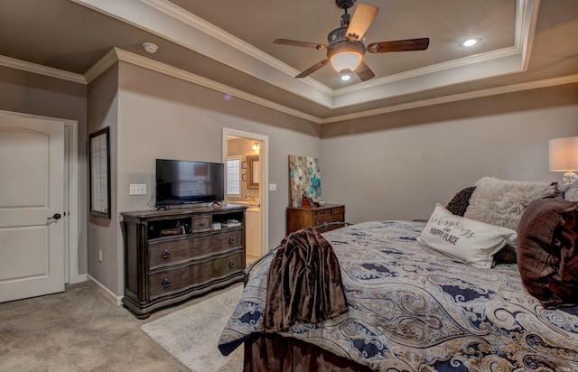 carpeted bedroom featuring a raised ceiling, crown molding, connected bathroom, and ceiling fan