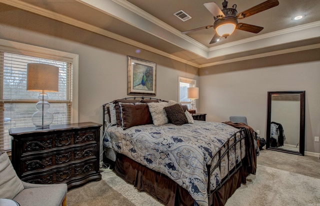 bedroom with ornamental molding, light colored carpet, and a tray ceiling