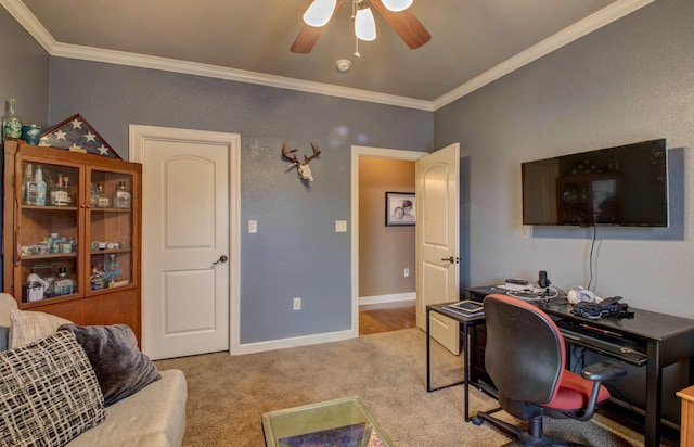 carpeted office space with ornamental molding and ceiling fan