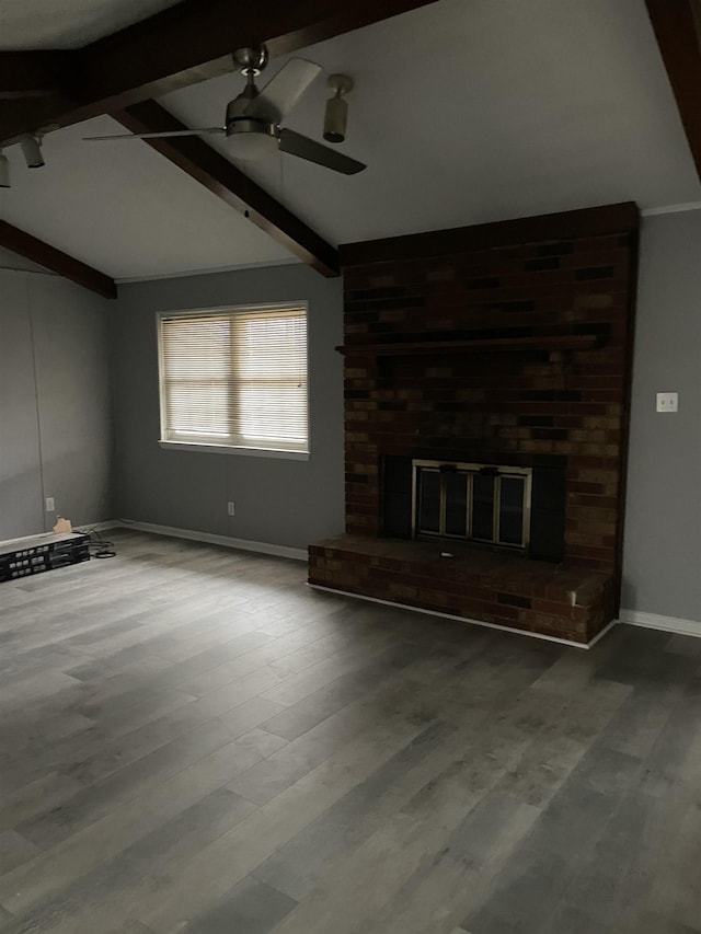 unfurnished living room with a brick fireplace, hardwood / wood-style flooring, lofted ceiling with beams, and ceiling fan