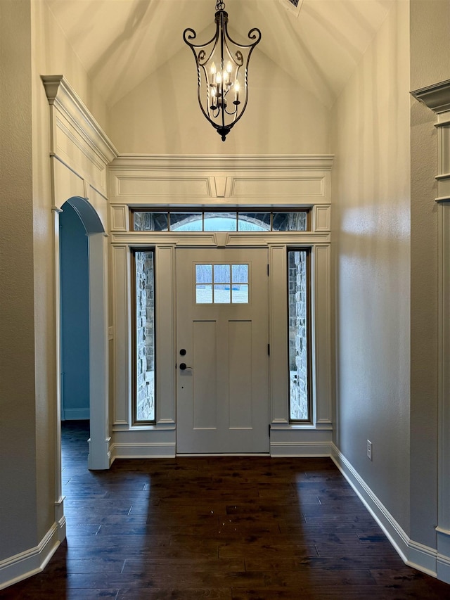 entrance foyer featuring dark wood-type flooring, high vaulted ceiling, and an inviting chandelier