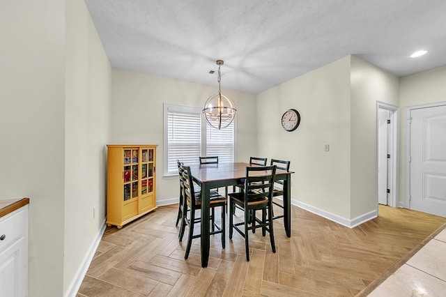 dining room featuring an inviting chandelier, a textured ceiling, and light parquet flooring