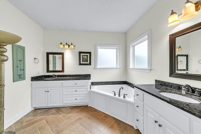 bathroom featuring vanity, a washtub, and parquet flooring