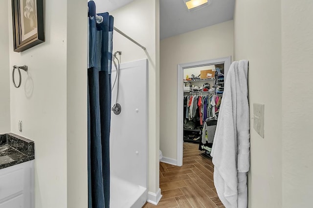 bathroom with a shower, parquet floors, and vanity