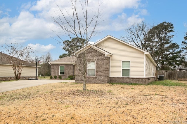 view of front of property with central AC and a front lawn