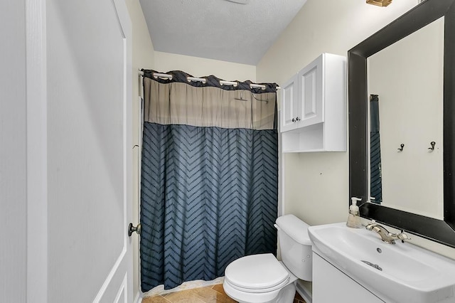 bathroom featuring walk in shower, sink, a textured ceiling, and toilet