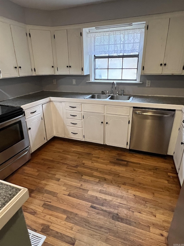 kitchen with white cabinetry, appliances with stainless steel finishes, sink, and wood-type flooring