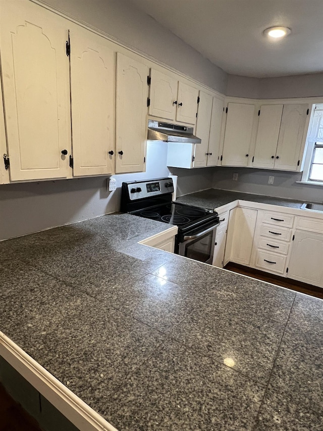 kitchen with white cabinets, sink, and electric range