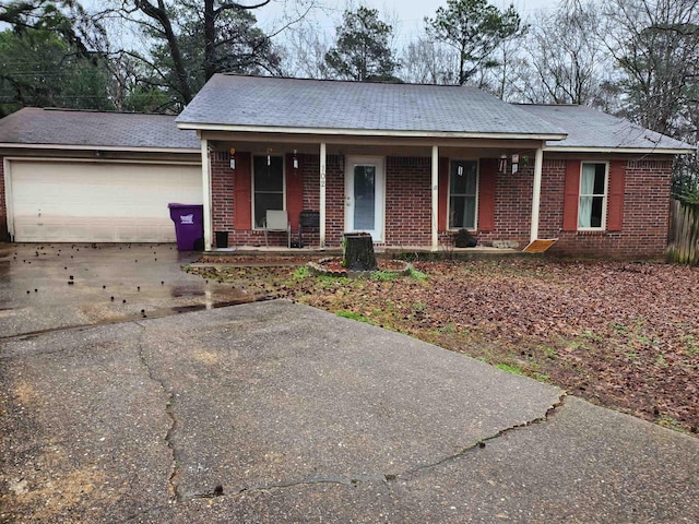 ranch-style house with driveway, a garage, a porch, and brick siding