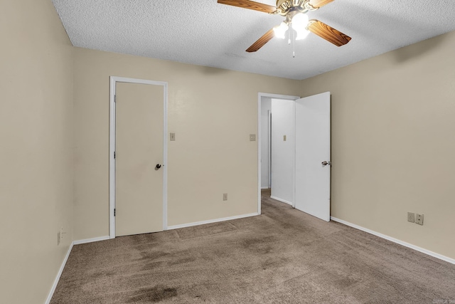 unfurnished bedroom with carpet, a textured ceiling, and baseboards