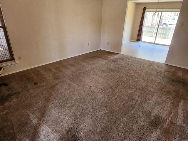 empty room with baseboards and dark carpet