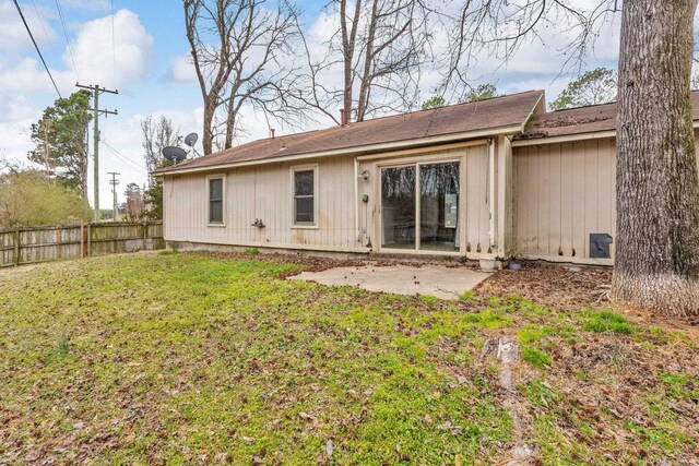 back of property featuring a patio area, fence, and a lawn