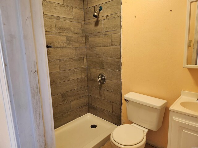 full bathroom featuring a shower stall, toilet, and vanity