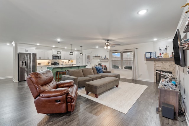 living room featuring ceiling fan, dark wood-type flooring, and a fireplace