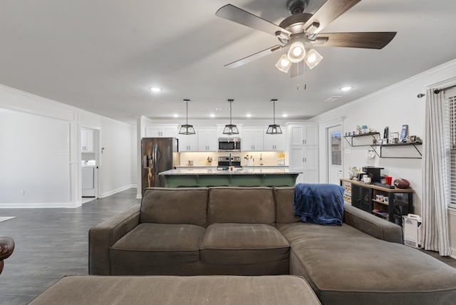 living room featuring ornamental molding, washer / dryer, dark hardwood / wood-style floors, and ceiling fan