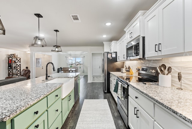 kitchen with sink, tasteful backsplash, appliances with stainless steel finishes, green cabinets, and white cabinets