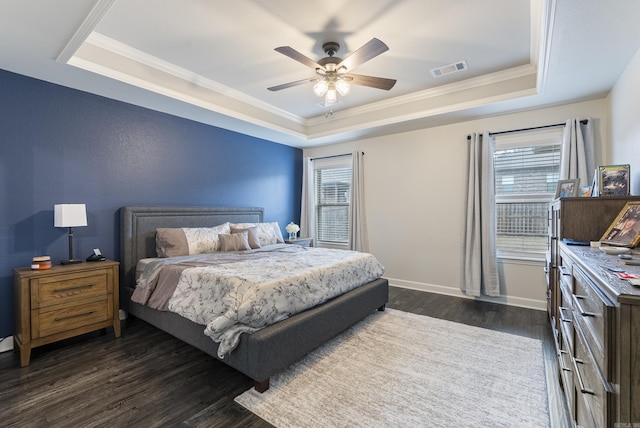 bedroom featuring dark hardwood / wood-style floors, ornamental molding, a raised ceiling, and ceiling fan