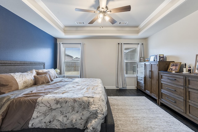 bedroom with a raised ceiling, crown molding, ceiling fan, and dark hardwood / wood-style flooring