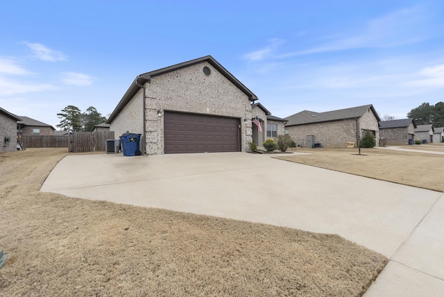 view of property exterior with a garage and cooling unit