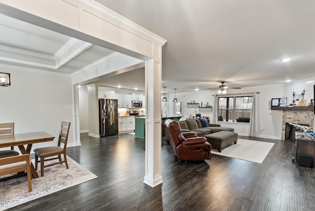 living room featuring dark wood-type flooring, ornamental molding, and ceiling fan