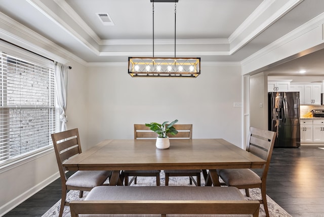 dining area featuring dark hardwood / wood-style floors, a tray ceiling, and crown molding