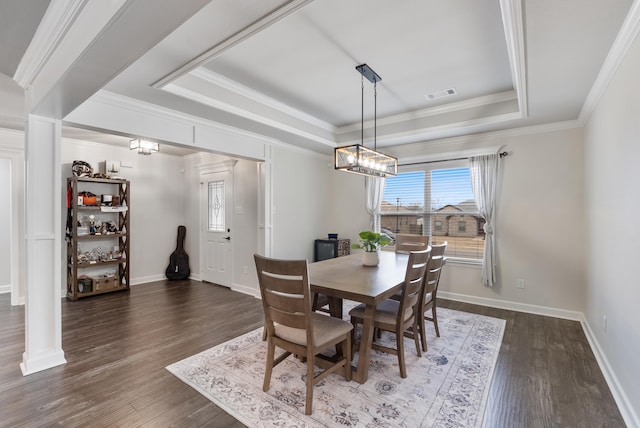 dining room with crown molding, a tray ceiling, and dark hardwood / wood-style floors