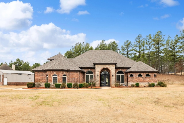 french country style house featuring french doors and a front lawn