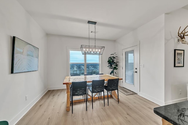 dining area featuring a notable chandelier and light hardwood / wood-style flooring