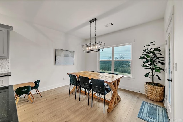 dining area with an inviting chandelier and light wood-type flooring