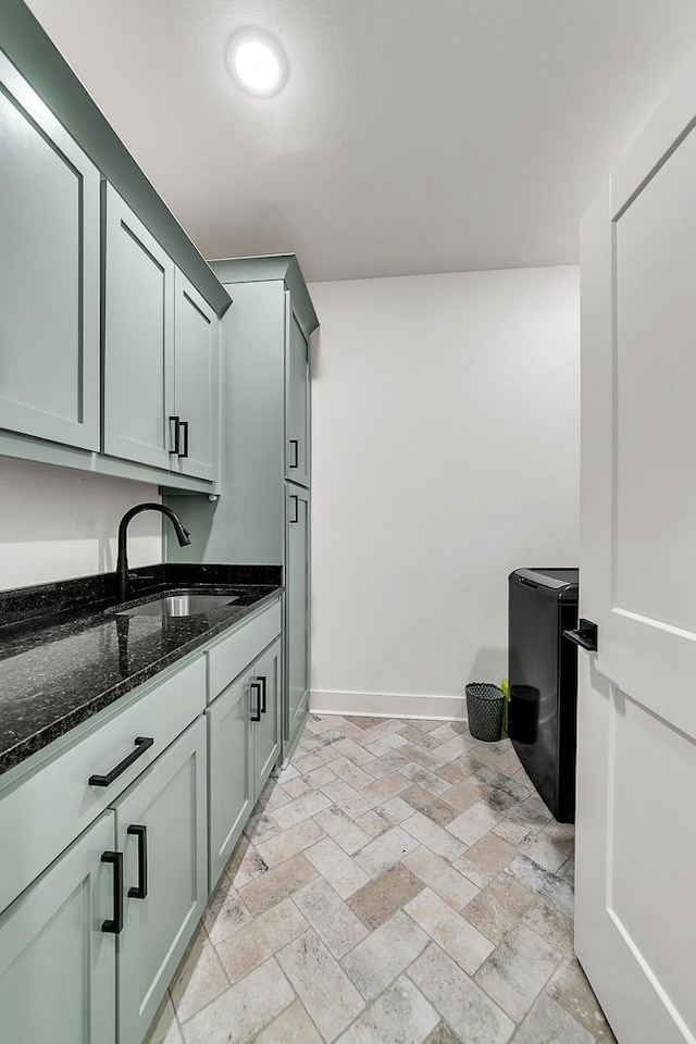 laundry room with sink and dark stone countertops