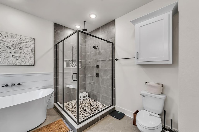 bathroom featuring tile patterned flooring, shower with separate bathtub, and toilet