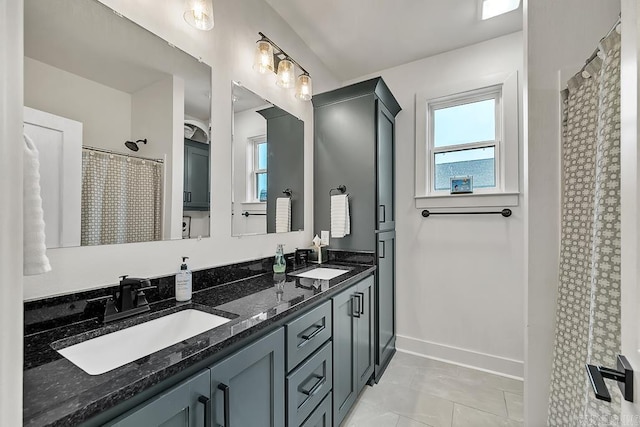 bathroom featuring tile patterned flooring, vanity, and curtained shower