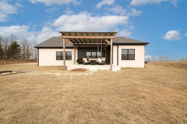 rear view of house with a pergola, a yard, and a patio area