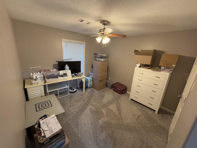 office featuring ceiling fan, dark carpet, and a textured ceiling